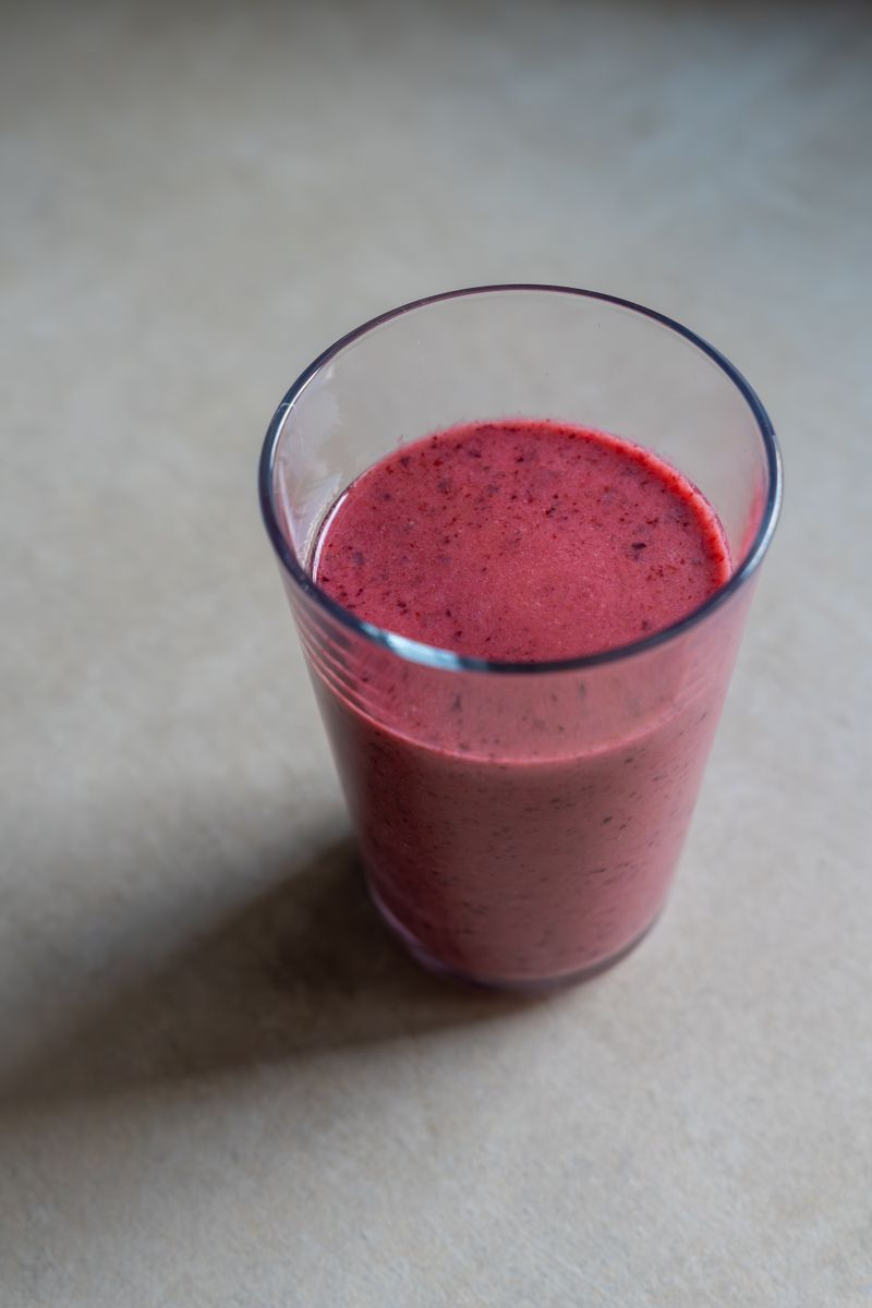 Sklenice fialového smoothie z lesního ovoce